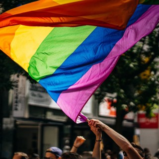 Eine Regenbogenflagge wird in der Luft geschwenkt