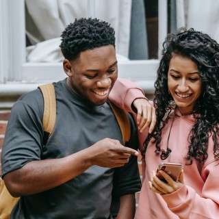 Zwei Teenager gucken gemeinsam in ein Smartphone