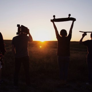 Jugendliche mit Skateboards im Sonnenuntergang